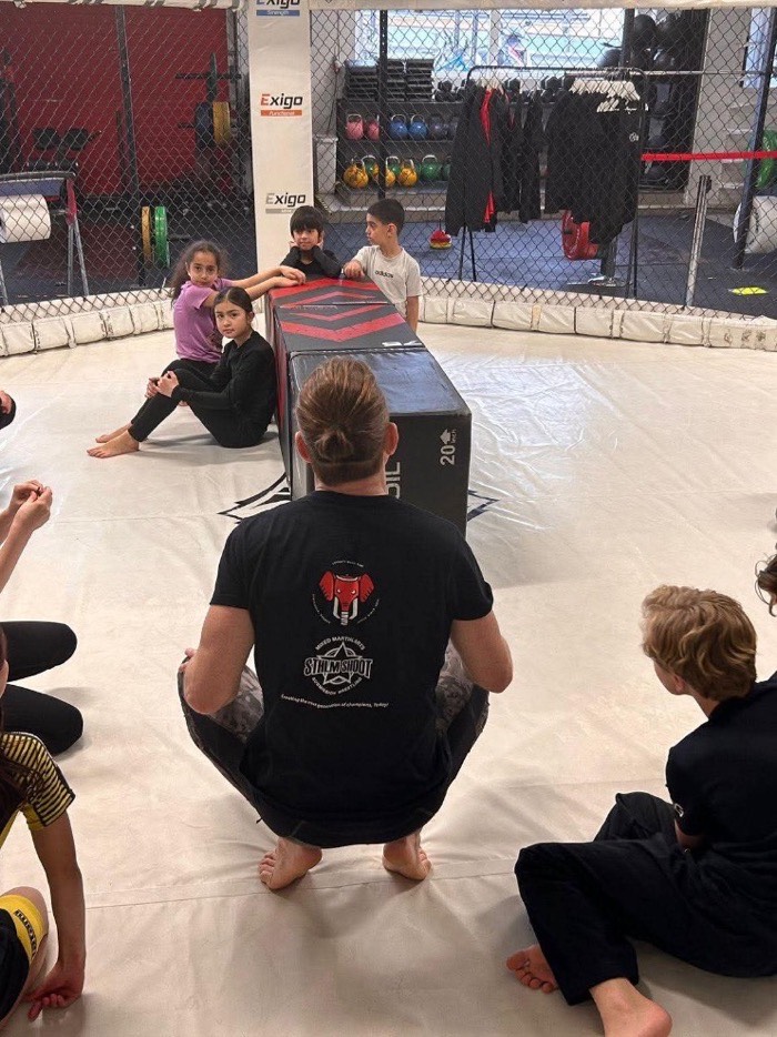 Coach Lech med BJJ-gruppen vid genomgång i buren, STHLM SHOOT i Bromma